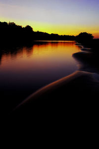 Scenic view of lake against sky at sunset