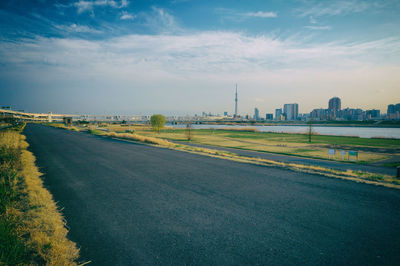 Road by river against tokyo cityscape