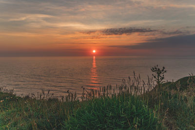 Scenic view of sea against romantic sky at sunset