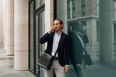 Mid adult woman holding umbrella in building