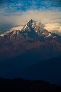 Scenic view of mountain peak against sky at sunset