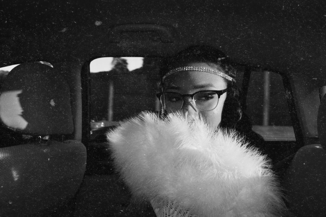 PORTRAIT OF YOUNG WOMAN IN SNOW COVERED CAR