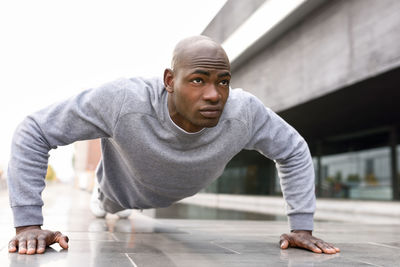 Man doing push-ups on footpath