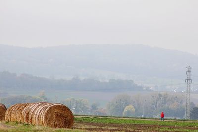 Hay bales on field against sky