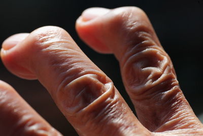 Close-up of person hand against black background