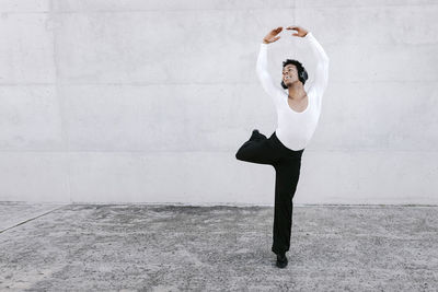 Full length of woman standing against wall