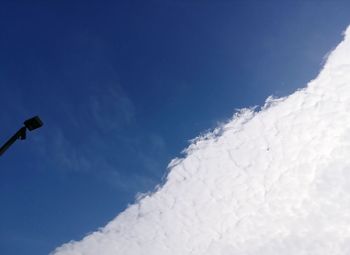 Low angle view of snow against blue sky