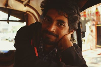 Portrait of young man sitting at vehicle