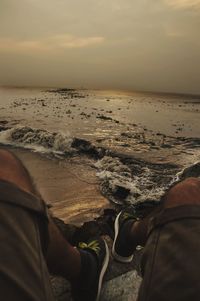 Low section of man standing on beach