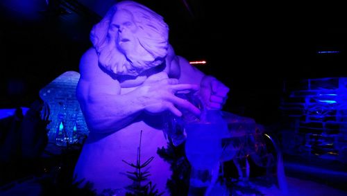 Illuminated statue against blue sky at night