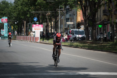 Man riding bicycle on road in city