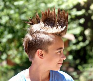 Close-up of girl with spiked hair against tree