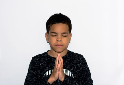 Portrait of boy standing against white background