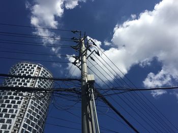 Low angle view of electricity pylon against blue sky