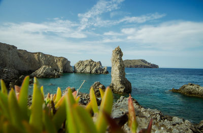 Scenic view of rocks in sea against sky