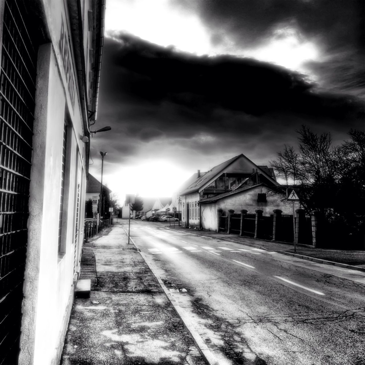 architecture, building exterior, built structure, sky, the way forward, cloud - sky, house, cloudy, cloud, diminishing perspective, residential structure, street, vanishing point, residential building, sunlight, building, empty, outdoors, road, day