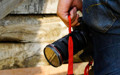 Midsection of man holding camera