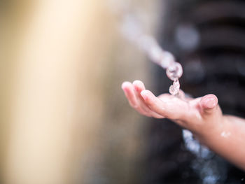 Close-up of hand holding water against blurred background