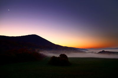 Scenic view of silhouette mountains against sky at sunset