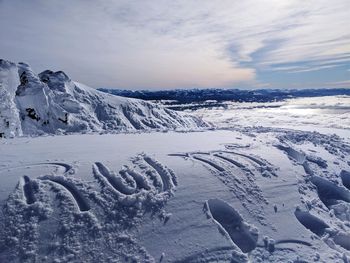 Snow covered landscape against sky