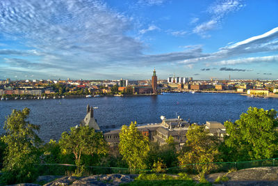 View of city and river against cloudy sky