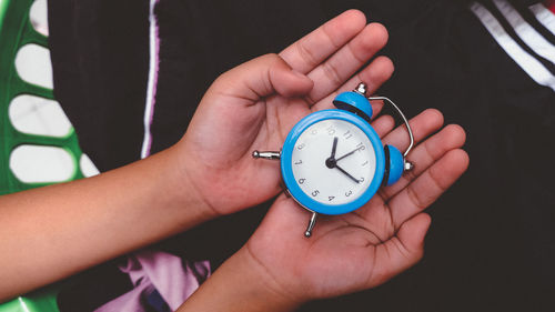 Cropped hand holding alarm clock