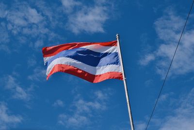 Low angle view of flag against blue sky