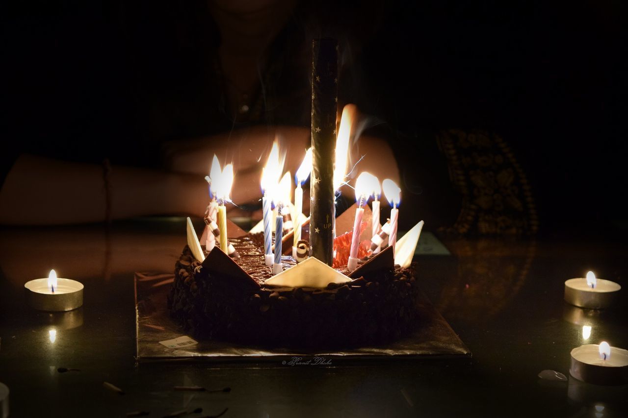 BURNING CANDLES ON BIRTHDAY CAKE IN KITCHEN