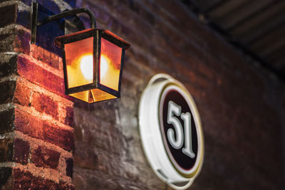 Low angle view of illuminated lamp mounted on wall