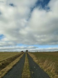 Country road against cloudy sky