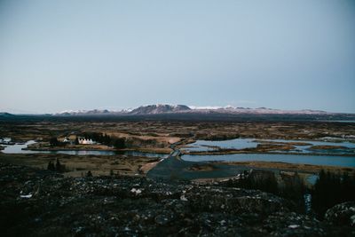 Scenic view of lake by buildings against clear sky