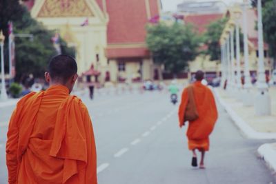 Monks walking on road leading towards temple