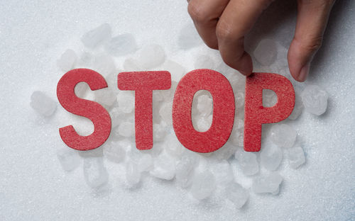 Cropped image of hand holding heart shape on wall
