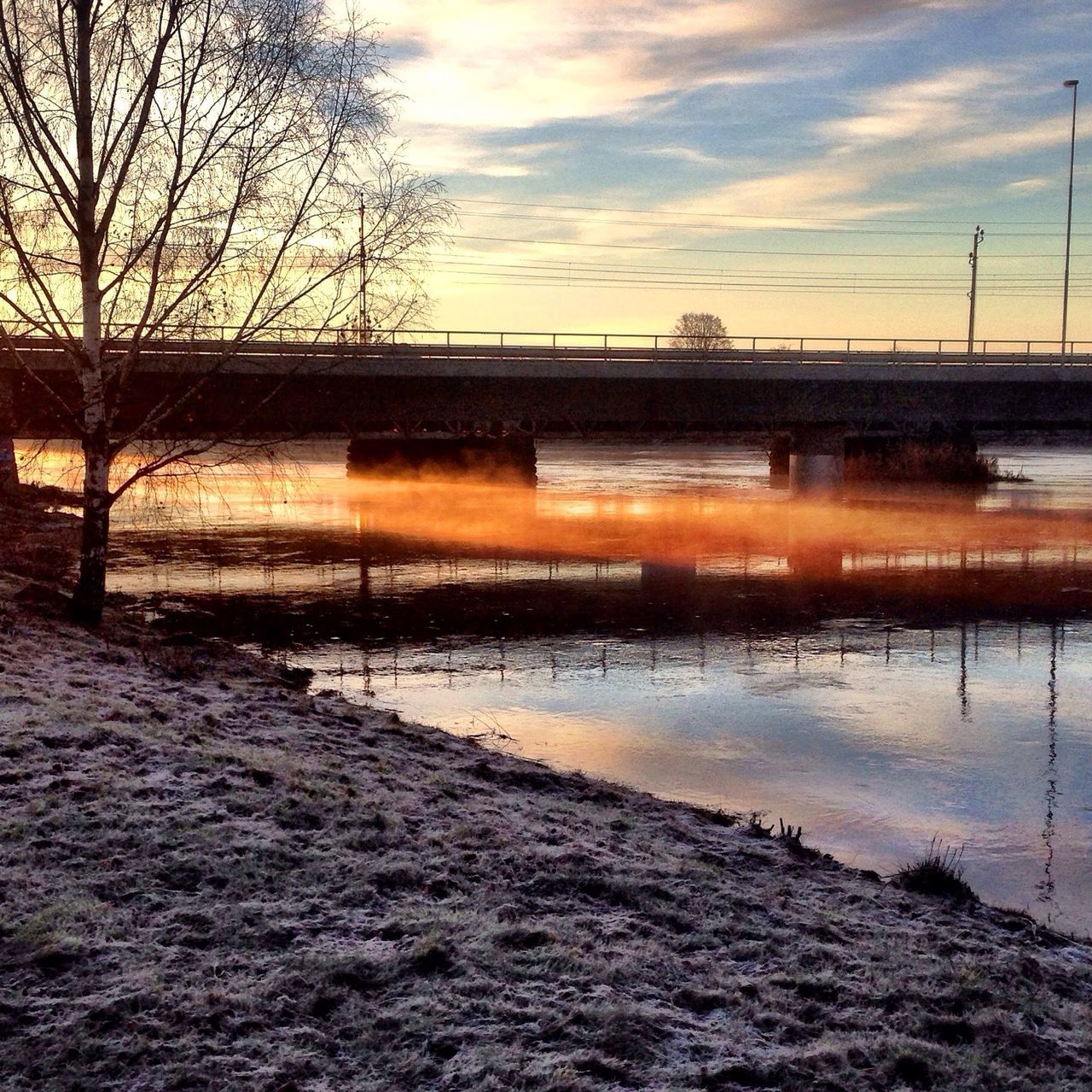 water, sky, sunset, connection, cloud - sky, river, bare tree, waterfront, bridge - man made structure, built structure, tranquility, nature, tranquil scene, reflection, scenics, architecture, beauty in nature, cloudy, cloud, tree