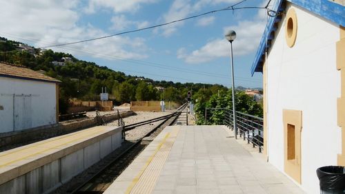 Railroad tracks against cloudy sky