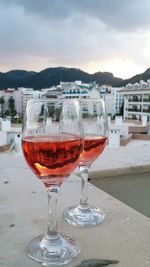 Close-up of wineglass on table against sky during sunset