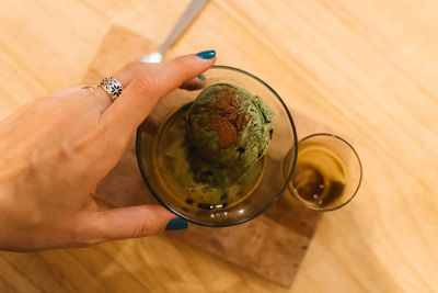 High angle view of hand holding tea cup on table