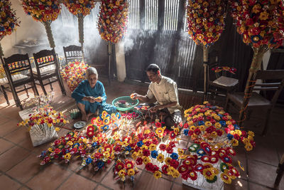 People sitting by flowers in shop