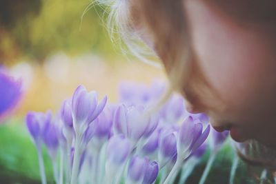 Close-up of girl smelling purple flower