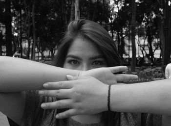 Close-up portrait of young woman against trees