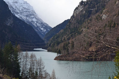 Scenic view of river by mountains against sky