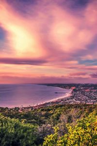 Scenic view of sea against dramatic sky during sunset