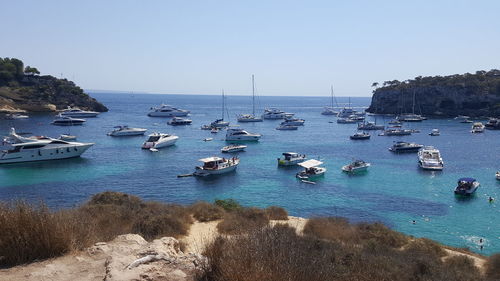 Boats moored on sea against clear sky