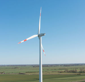 Windmill on field against clear sky