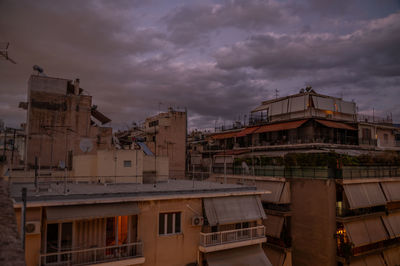 Buildings in city against cloudy sky