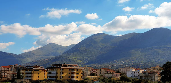 Houses in town against cloudy sky