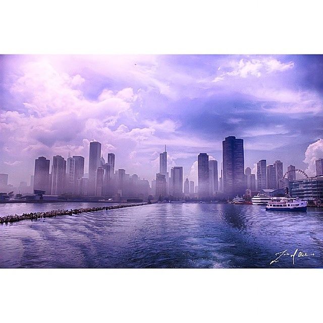 building exterior, city, architecture, water, built structure, skyscraper, cityscape, sky, urban skyline, waterfront, transfer print, river, skyline, tower, financial district, auto post production filter, office building, tall - high, cloud - sky, modern