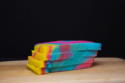 Close-up of multi colored pencils on table against black background