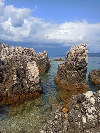 Rocks in sea against sky