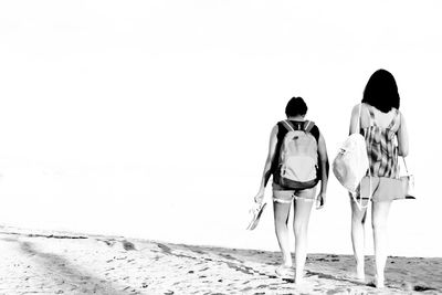 Rear view of women walking on beach